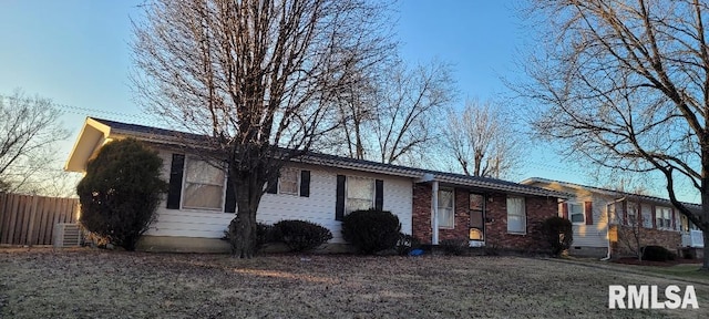 single story home with brick siding, cooling unit, and fence