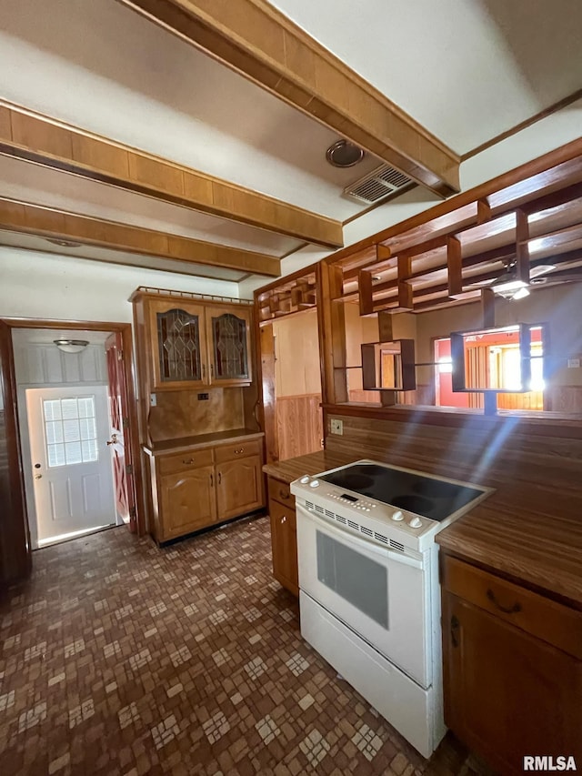 kitchen with brown cabinetry, white range with electric stovetop, visible vents, and glass insert cabinets