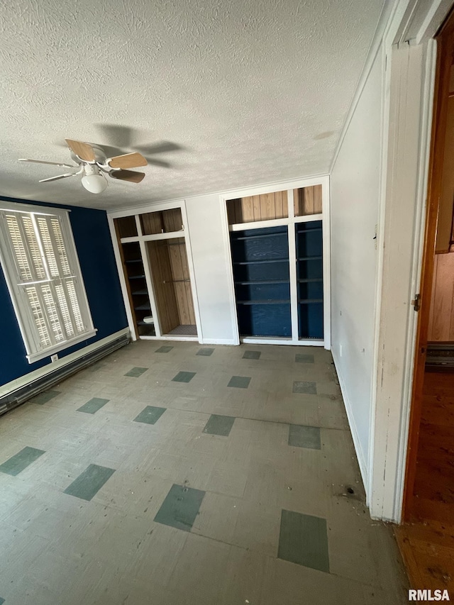 interior space featuring a baseboard heating unit and a ceiling fan