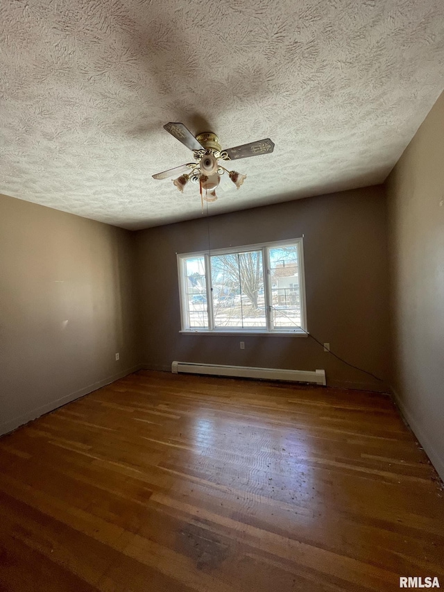 empty room featuring baseboard heating, dark wood-type flooring, a ceiling fan, a textured ceiling, and baseboards