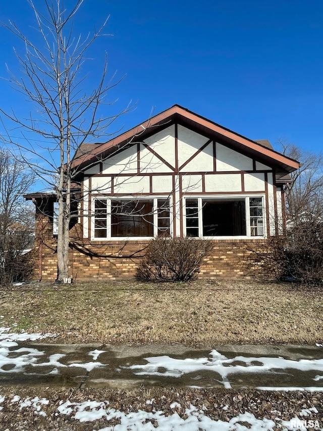 snow covered rear of property with stucco siding