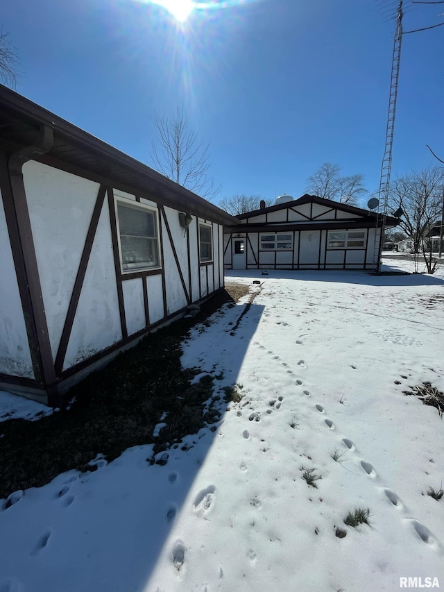 view of snowy exterior with a carport and stucco siding