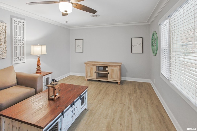 living area featuring baseboards, light wood finished floors, visible vents, and crown molding