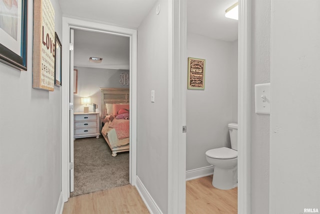 bathroom featuring baseboards, toilet, and wood finished floors