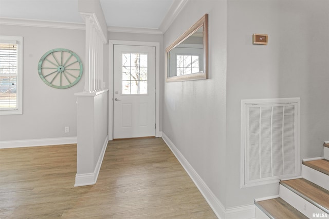 entryway with stairs, visible vents, light wood-style flooring, and a healthy amount of sunlight