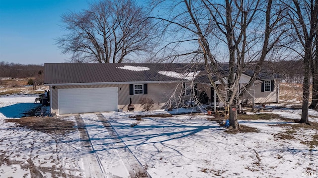 ranch-style home featuring metal roof and an attached garage