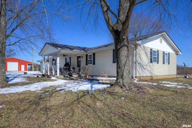 view of front of property featuring a detached garage, an outbuilding, and a porch