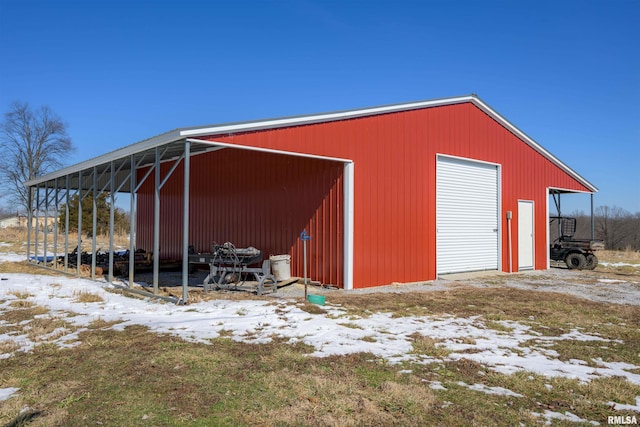 snow covered structure featuring an outbuilding and an outdoor structure