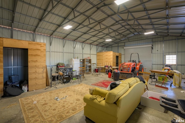 garage with a workshop area, metal wall, and freestanding refrigerator