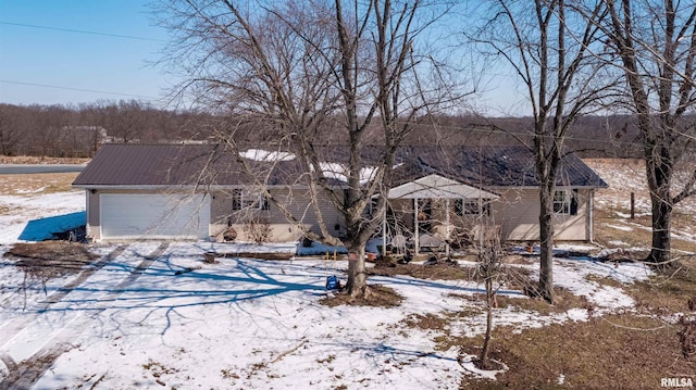 view of front facade with an attached garage and metal roof