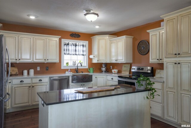 kitchen with a center island, dark wood-style floors, appliances with stainless steel finishes, and a sink