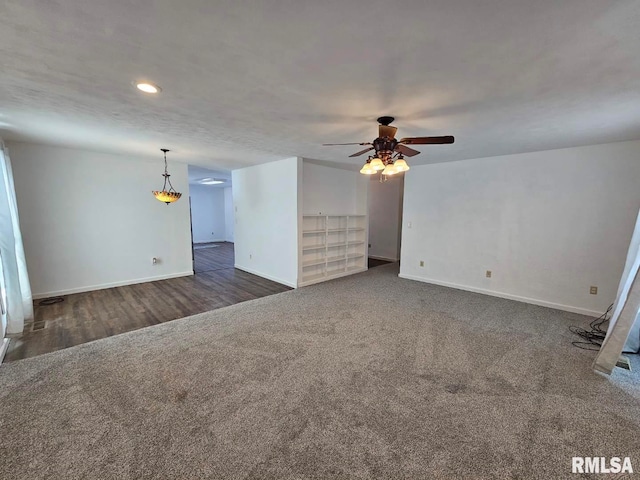 unfurnished living room featuring dark carpet, baseboards, and ceiling fan