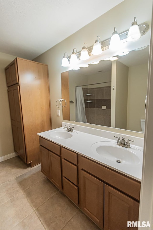 full bath with double vanity, a shower with curtain, a sink, and tile patterned floors