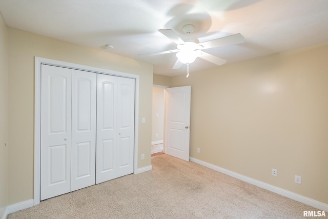 unfurnished bedroom featuring a closet, light colored carpet, ceiling fan, and baseboards