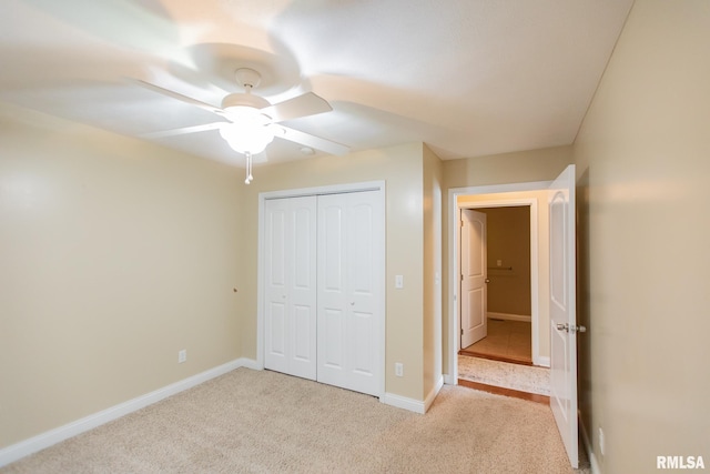 unfurnished bedroom featuring a ceiling fan, a closet, light carpet, and baseboards