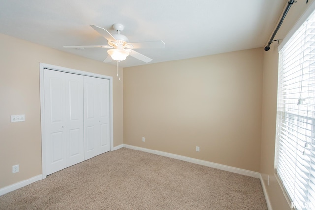 unfurnished bedroom featuring carpet floors, a closet, a ceiling fan, and baseboards