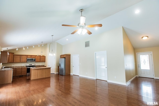 kitchen featuring a kitchen island, visible vents, open floor plan, appliances with stainless steel finishes, and brown cabinetry