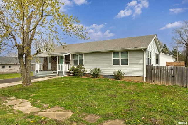 ranch-style home with a front yard and fence