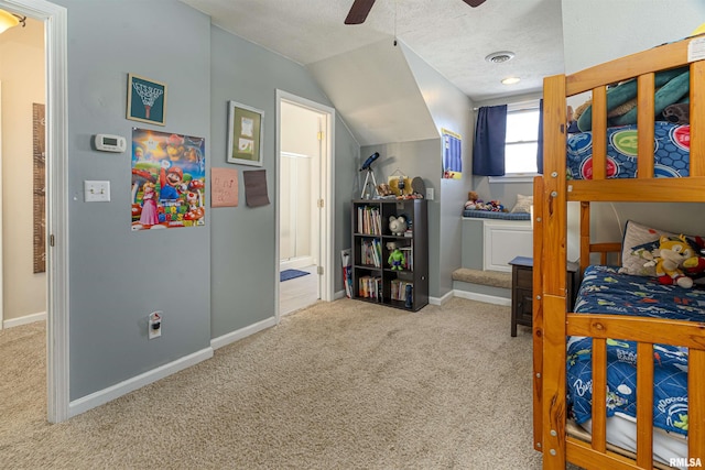 bedroom featuring lofted ceiling, light colored carpet, connected bathroom, a textured ceiling, and baseboards