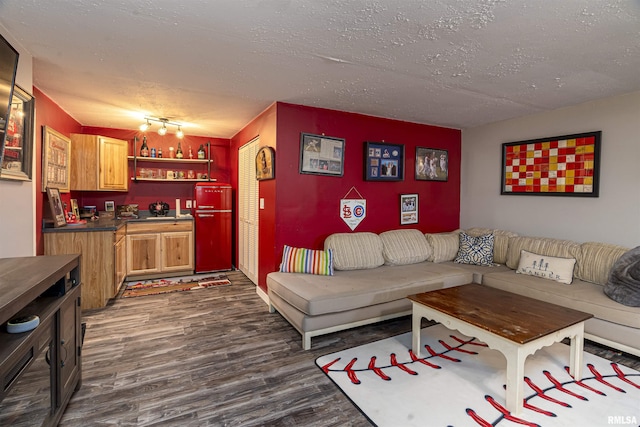 living area with a textured ceiling, wet bar, and dark wood-style flooring