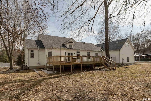 back of property featuring a shingled roof and a deck