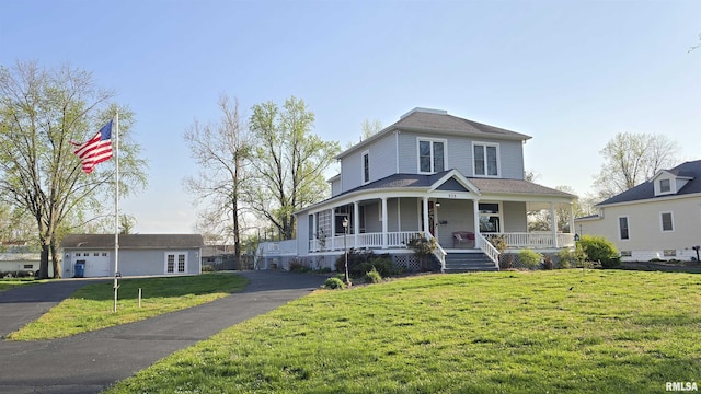 farmhouse with a front yard, a porch, and an outbuilding