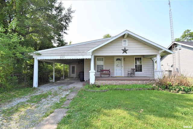 view of front of property featuring driveway, covered porch, a front lawn, and an attached carport