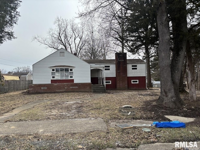 view of front of house featuring crawl space, fence, and a chimney