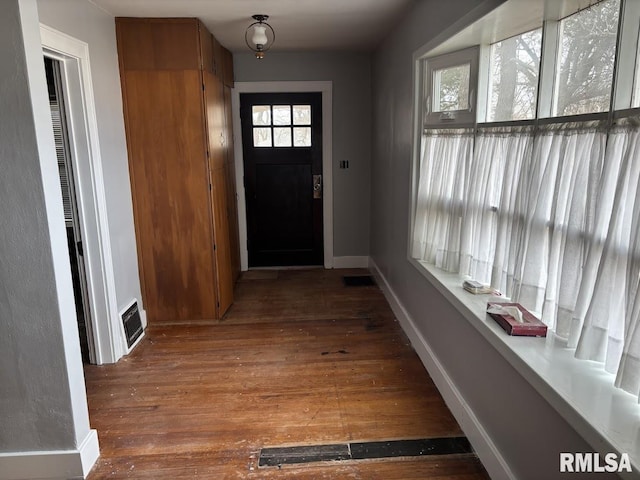 entryway featuring dark wood-style flooring, visible vents, and baseboards