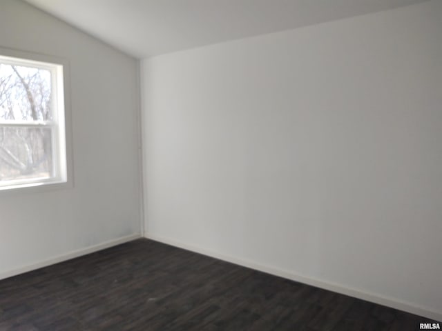 empty room featuring dark wood-style flooring and baseboards