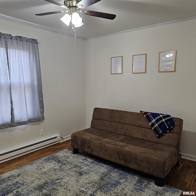 sitting room featuring crown molding, dark wood finished floors, a baseboard heating unit, a ceiling fan, and baseboards