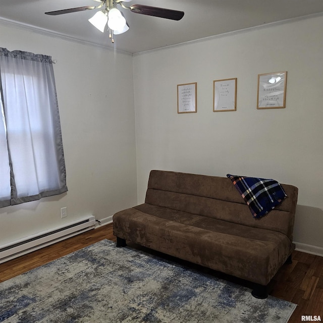 living area with baseboards, ceiling fan, dark wood-style flooring, crown molding, and a baseboard heating unit