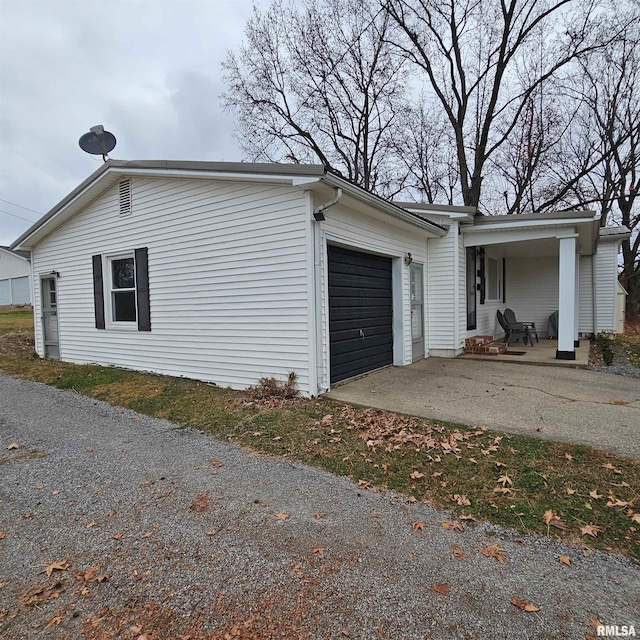 view of property exterior featuring a porch, driveway, and an attached garage