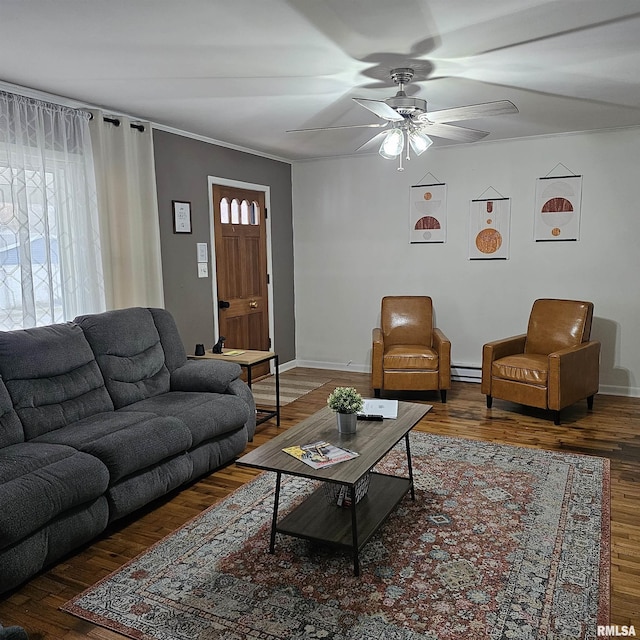 living area with a baseboard radiator, dark wood finished floors, baseboards, and ceiling fan