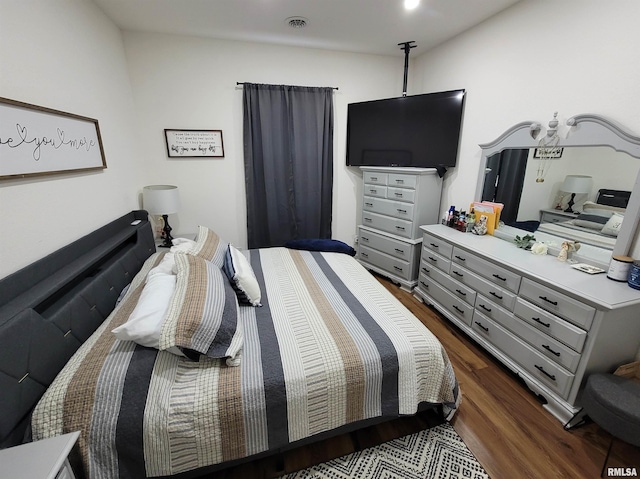 bedroom featuring visible vents and dark wood finished floors