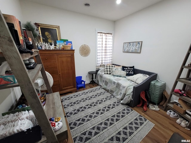 bedroom featuring visible vents and wood finished floors