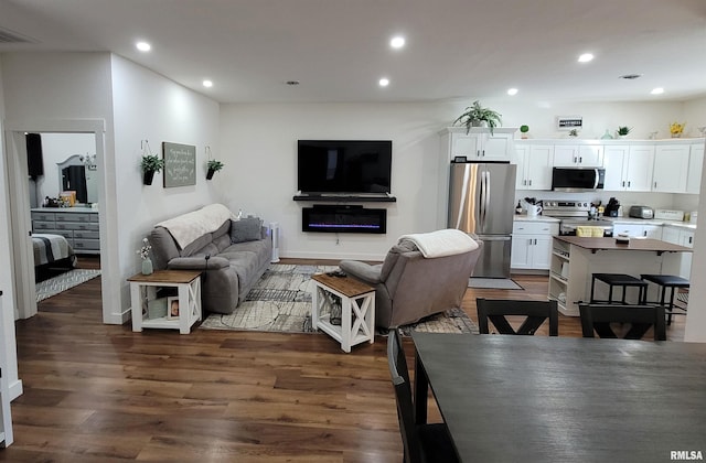 living room with dark wood-style floors, recessed lighting, and visible vents