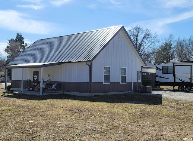 rear view of property featuring metal roof, a patio, central AC, a yard, and a standing seam roof