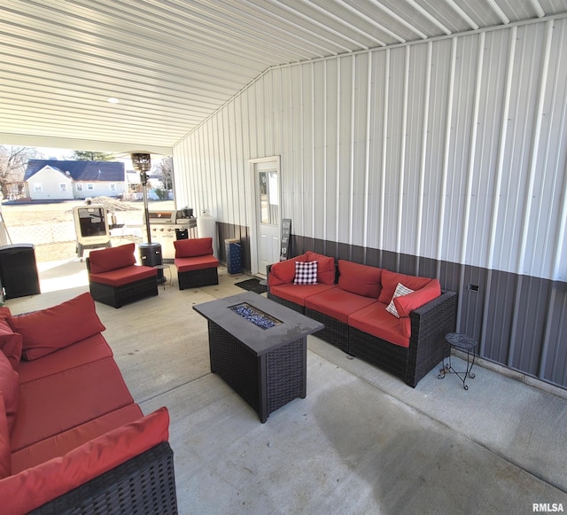 view of patio with an outdoor living space with a fire pit