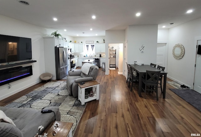 living area with baseboards, dark wood finished floors, visible vents, and recessed lighting