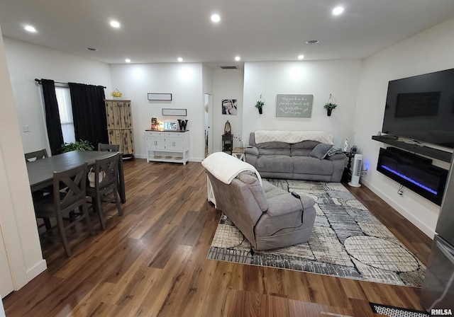 living room featuring dark wood-style floors, visible vents, baseboards, and recessed lighting