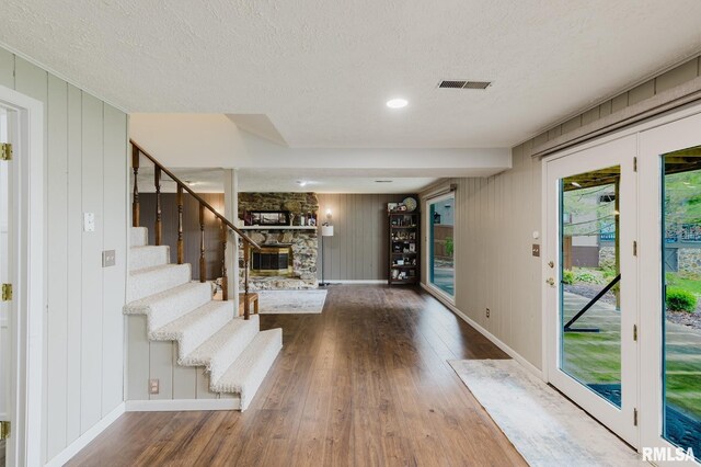 1437 Nassau Ln, Marion, IL 62959 - entryway with wood-type flooring, a stone fireplace, a textured ceiling, baseboards, and stairs