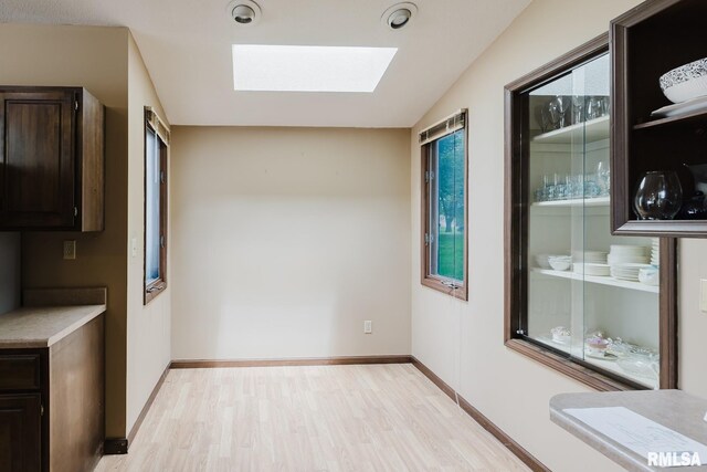 1437 Nassau Ln, Marion, IL 62959 - unfurnished dining area with a skylight, light wood-style floors, and baseboards