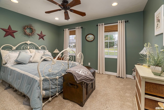 bedroom featuring multiple windows, recessed lighting, light colored carpet, and baseboards