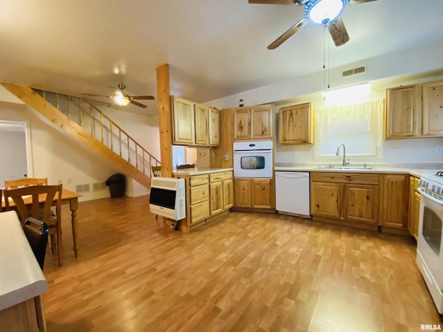 kitchen featuring white appliances, a sink, visible vents, light countertops, and heating unit