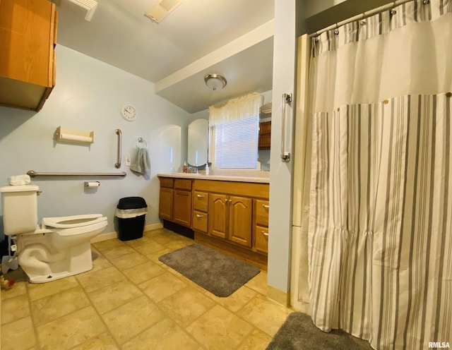 bathroom featuring toilet, visible vents, vanity, baseboards, and stone finish floor