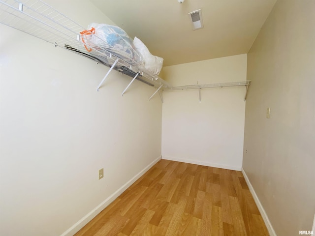 walk in closet with light wood finished floors and visible vents