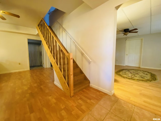 stairs featuring ceiling fan, baseboards, and wood finished floors