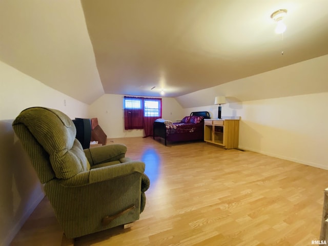 bedroom with vaulted ceiling, baseboards, and light wood-style floors