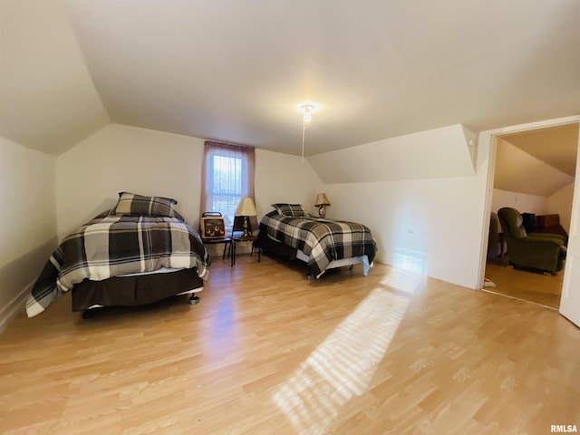 bedroom featuring lofted ceiling and light wood-style flooring